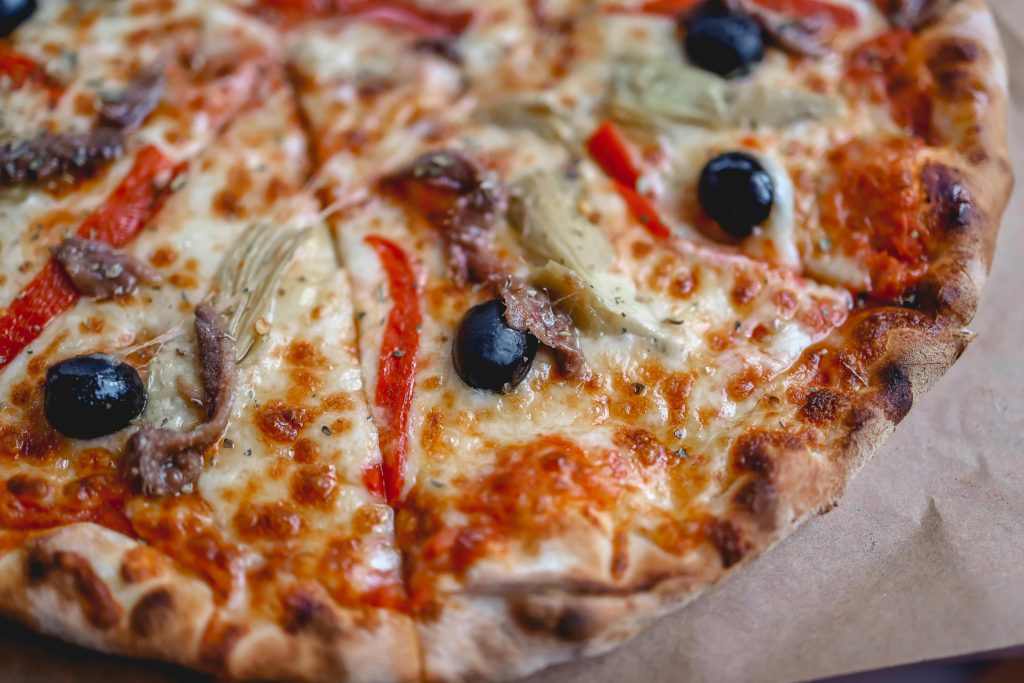 Pizza maison dorée avec mozzarella fondue, tomates et basilic frais